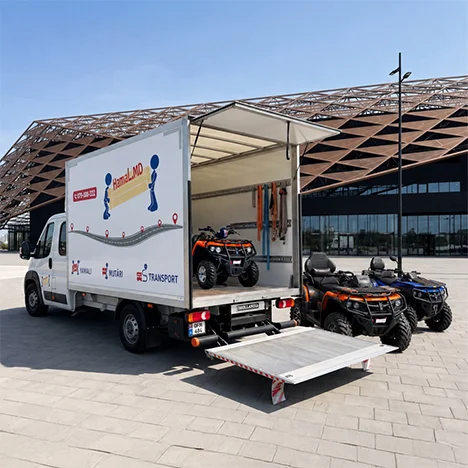 Trei ATV-uri sunt încărcate pe rampă într-un camion prelată.